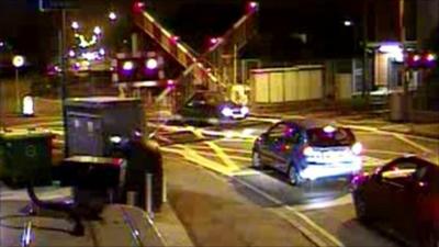 Car driving under level crossing barriers