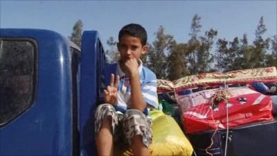 Boy on back of truck leaving Sirte