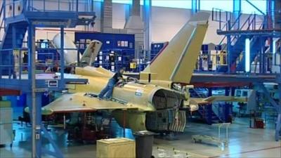 Man working on jet fighter plane