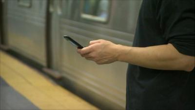 New York commuter uses mobile phone underground