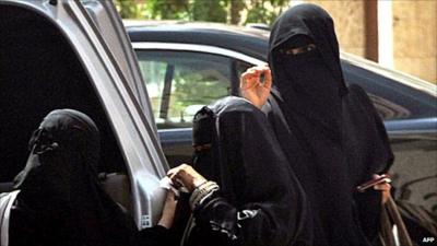 Saudi women in Riyadh stand by a car