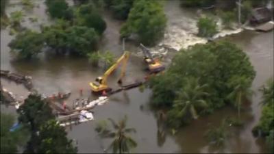 Mechanical diggers building flood defences