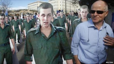 Noam Shalit standing near cardboard cut-outs of his son Gilad Shalit during a protest in Jerusalem