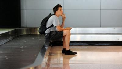 A traveller waiting for luggage at the Qantas baggage carousel after flight cancellations at Sydney Airport on October 10, 2011