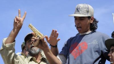 Libyan fighter brandishes a pistol