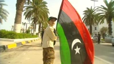 A boy holding a Libyan flag