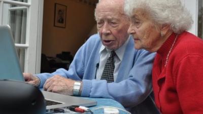 George Higgs showing Stella Fawcett how to use a computer