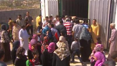 Libyan's gather outside cold storage container holding the body of Gaddafi's son