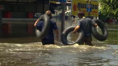 Men wading through thigh-deep water just north of Bangkok