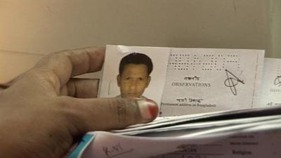 A man sifts through Bangladesh employment records