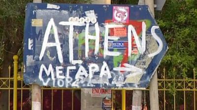 Graffiti sign pointing towards Athens