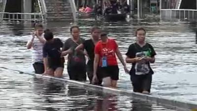 People wade through water in Thailand