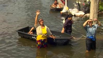 A Thai woman calls for help in a flooded part of Bangkok