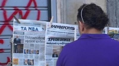 Man in Greece looking at newspapers