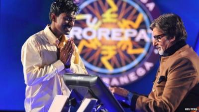 Sushil Kumar joins his hands together past Bollywood actor Amitabh Bachchan after winning about $1 million on an Indian game show in Mumbai
