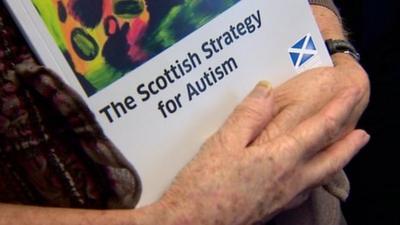 Elderly lady holding Scottish Strategy for Autism report