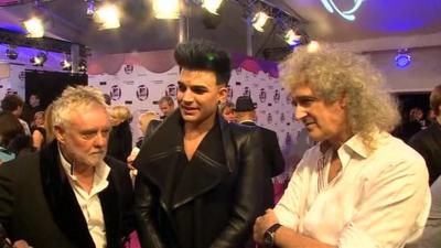 Roger Taylor (L), Adam Lambert (C), and Brian May (R)