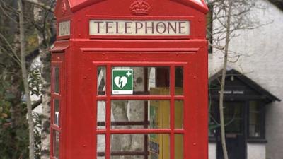 Red telephone box with a defibrillator sign