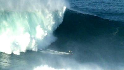 Surfer rides gigantic wave