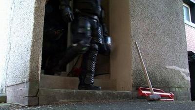 Police officers leaving a house