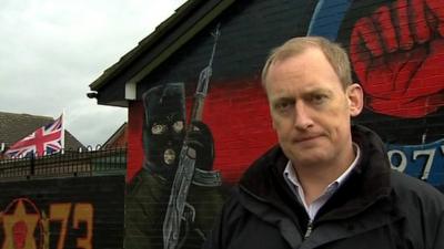 The BBC's Andy Martin in front of a paramilitary mural