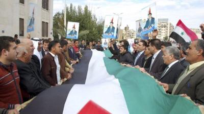 People attend a rally to show support for Syria"s President Bashar al-Assad in Hama