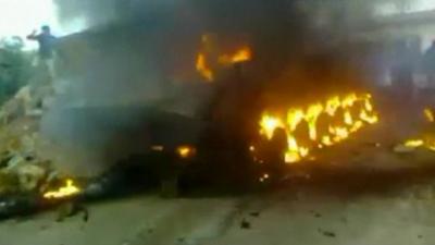 A Syrian Army APC burns in the city of Deraa