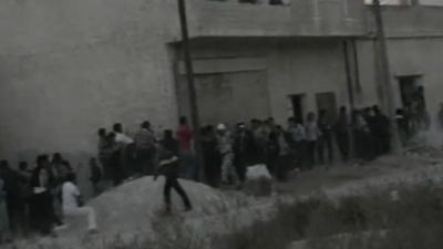 Protesters take cover from fire in Syria