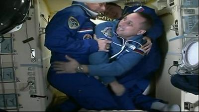 Crew member coming through a hatch on the ISS