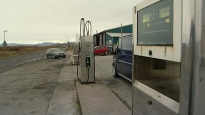 Cars at fuel pumps on a remote road