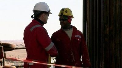 Oil workers shake hands