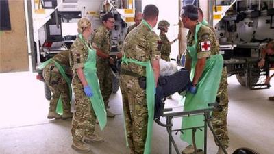 Military medics working at Camp Bastion hospital receive a battlefield casualty