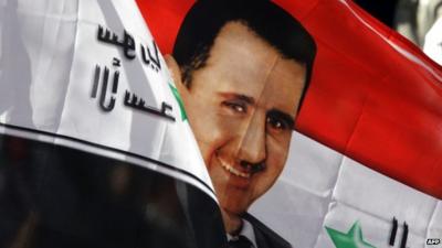 A Syrian flag with an image of President Bashar al-Assad