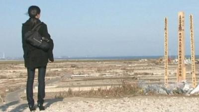 Woman at memorial for tsunami dead in Sendai, Japan