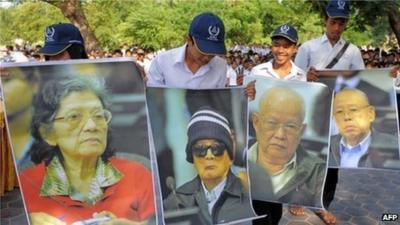 Cambodian students hold up posters of former Khmer Rouge leaders