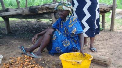 Women in Africa with nuts and a bucket