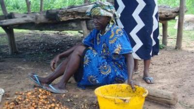 Women in Africa with nuts and a bucket