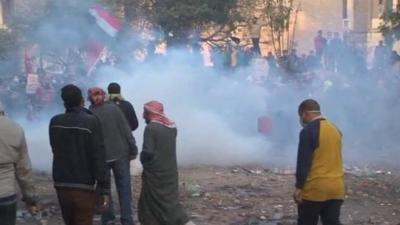 Protesters gathered with Egyptian flags in clouds of tear gas