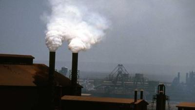 Smoke billows from factory chimneys