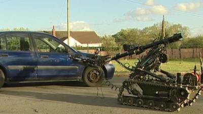 Bomb disposal robot approaches car