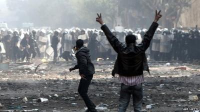 An Egyptian protester shows the V-sign for victory during clashes with riot police