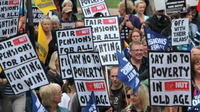 Protesters hold placards in Nottingham city centre during a one day national strike against pension changes in June 2010