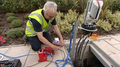 Workman installing cables under pavement