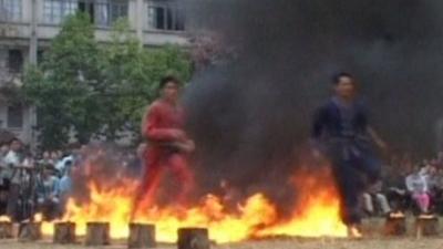 The Chinese ethnic athletes are running through fire at the sports festival.