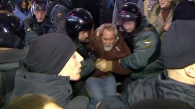 Security forces holding a protester