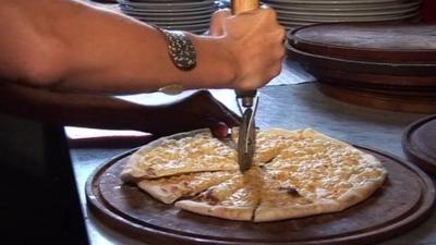 A pizza being cut