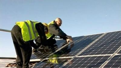 Solar panels being fitted on a roof