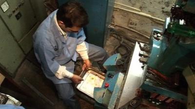 An Indian man works on an ore extraction machine