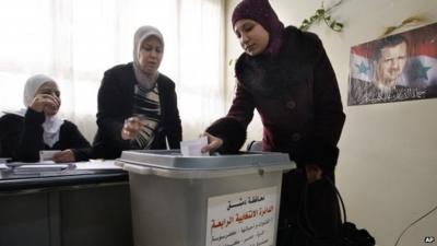 A woman casts her vote in Damascus, Syria