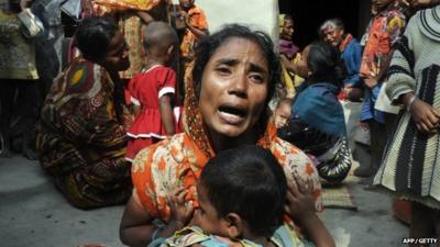 Relatives of victims mourn near the dead body of their kin in Sangram Nagar village